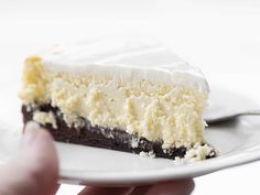 a person holding a piece of cake on a plate