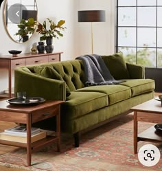 a living room with a green couch and coffee table in front of a large window