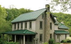 a house with a green roof in the woods