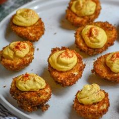 small crab cakes with yellow sauce on a white plate