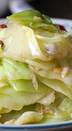 a close up of a plate of food with lettuce and sauce on it