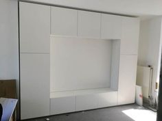 an empty room with white walls and cabinets