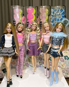 several barbie dolls are standing next to each other