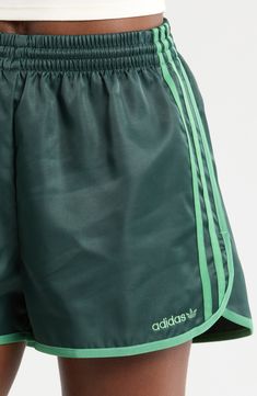 Lightweight and comfortable, these shorts made of recycled fibers sport dolphin hems for easy movement. 2 1/2" inseam; 28" leg opening; 12" front rise; 16 1/2" back rise (size Small) Elastic waist 100% recycled polyester Machine wash, line dry Imported Athleisure Athletic Shorts With Three Stripes, Casual Green Bottoms With Three Stripes, Sporty Green Athletic Shorts For Spring, Three Stripes Gym Bottoms For Summer, Green Sportswear Bottoms With Three Stripes, Green Athletic Shorts For Sports In Spring, Green Athletic Shorts For Spring Sports, Spring Green Athletic Shorts For Sports, Green Nylon Sportswear Shorts