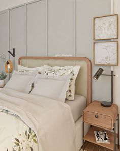 a bed with white sheets and pillows next to a night stand on a wooden floor