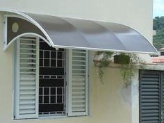 an awning on the side of a building with shutters open