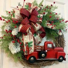 a christmas wreath with a red truck and evergreens