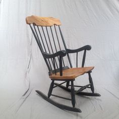 a wooden rocking chair sitting on top of a white sheet