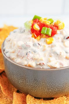 a bowl filled with white dip surrounded by tortilla chips