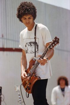 a young man is playing an electric guitar