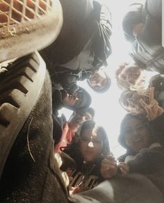 a group of people standing next to each other in front of a window with the sun shining through them