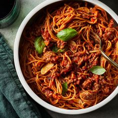 a white bowl filled with spaghetti and meat sauce