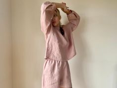 "A set of two in blush pink. Features an oversized box fit softened (pre washed) linen shirt with wide arms and a front pocket. Neck line with the bow. Mid rise, the loose fitting boxer style shorts have an elastic waist for extra comfort. Can be worn at home, in bed or out. Shirt length approximately 60cm (23\"1/2) Shorts length approximately 40cm (15\"3/8) Color on model blush pink. Made from 100% stone washed European linen. Wash in 30-40 degrees. Possible tumble dryer in low." Linen Pajamas, Style Shorts, European Linens, Womens Pyjama Sets, Pajamas Set, Tumble Dryer, Linen Shirt, Front Pocket, Blush Pink