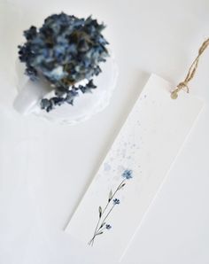 a piece of paper with blue flowers on it next to a white plate and bowl