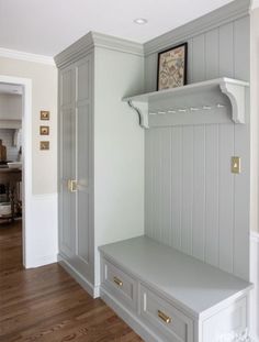 an empty room with some gray cabinets and shelves on the wall, along with wood flooring