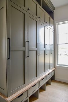 an empty room with many cabinets and drawers on the wall, in front of a window