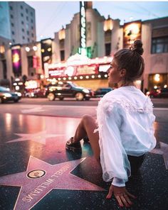 a woman sitting on the hollywood walk of fame