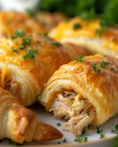 several croissants on a plate with cheese and parsley sprinkled on top