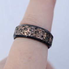 a close up of a person's hand wearing a ring with an image on it