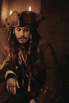 a man dressed as captain jack sparrow in a dark room