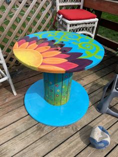 a painted table sitting on top of a wooden deck