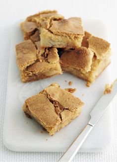 pieces of dessert sitting on top of a white plate next to a knife and fork