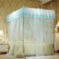 a bed with a white canopy and blue trimmings on the top, next to a night stand