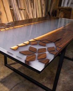 a table made out of wood and metal with geometric designs on the top, sitting in a shop