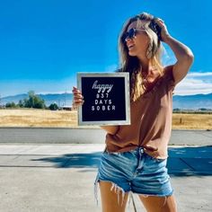 a woman holding up a sign that says happy birthday