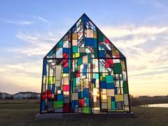 a house made out of stained glass sitting in the grass