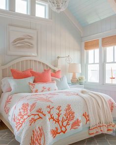 a bedroom with white walls and orange coral bedding