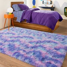 a bedroom with purple and blue decor on the walls, rugs and bedding