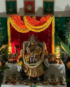 an idol is displayed in front of a decorated stage with flowers and candles on it