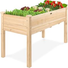 a wooden planter filled with lots of green plants