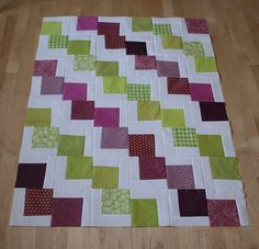 a patchwork quilt sitting on top of a wooden floor