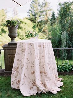 a table with an umbrella and flowers on it