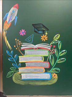 a chalkboard with books and a rocket ship on it, painted on the wall