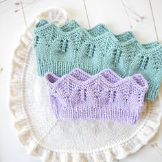 three knitted crowns sitting on top of a doily