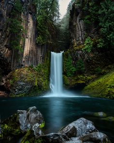 a large waterfall in the middle of a forest