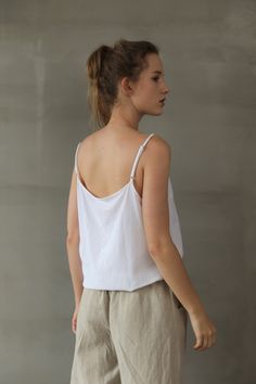 "Adorable camisole top by Nature Chic. 100% linen construction, this slip top is simply the best. Relaxed fit, straight cut, adjustable spaghetti straps, and classic V neckline, all these elements work together to create a versatile essential top. It is not only good for summer but also nice for fall underneath a shirt or jacket. -Prewashed linen -Straight cut but roomy -V-neck -Adjustable spaghetti straps sitting neatly at shoulders -Length and bottom hem suitable for tucked-in or un-tucked. -C White Linen Cami Tank Top, Summer Linen V-neck Camisole, White Linen Camisole Top, White Linen Camisole, Linen Sleeveless Camisole With Adjustable Straps, White Linen Cami Top, Summer Linen Tank Top With Adjustable Straps, Linen Camisole Top For Beach, Spring Linen Camisole Top