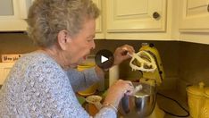 an older woman is using a mixer in the kitchen