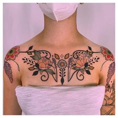 a woman wearing a face mask with tattoos on her chest