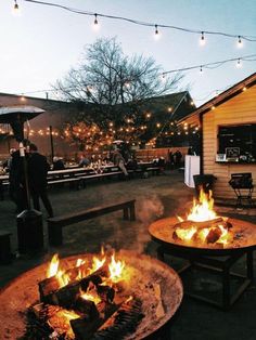 two fire pits sitting on top of a wooden table next to an open fire pit