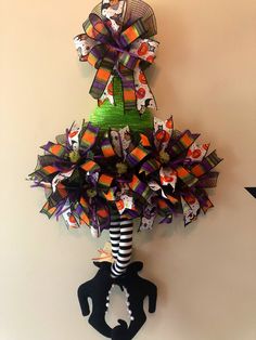 a christmas tree made out of paper and ribbon on top of a black key holder