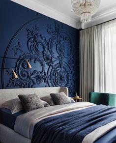 a large bed sitting under a blue wall in a bedroom