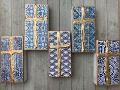 several blue and white tiles are arranged on a wooden surface, with gold foil wrapped around them