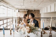 a bride and groom kissing at their wedding table