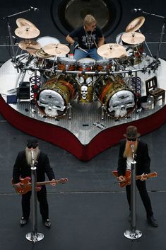 two men in suits are playing drums on stage