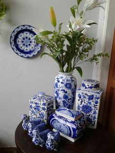 a vase with flowers in it sitting on a table next to other blue and white objects