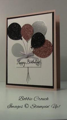 a happy birthday card with balloons and glitters on it, sitting on a shelf